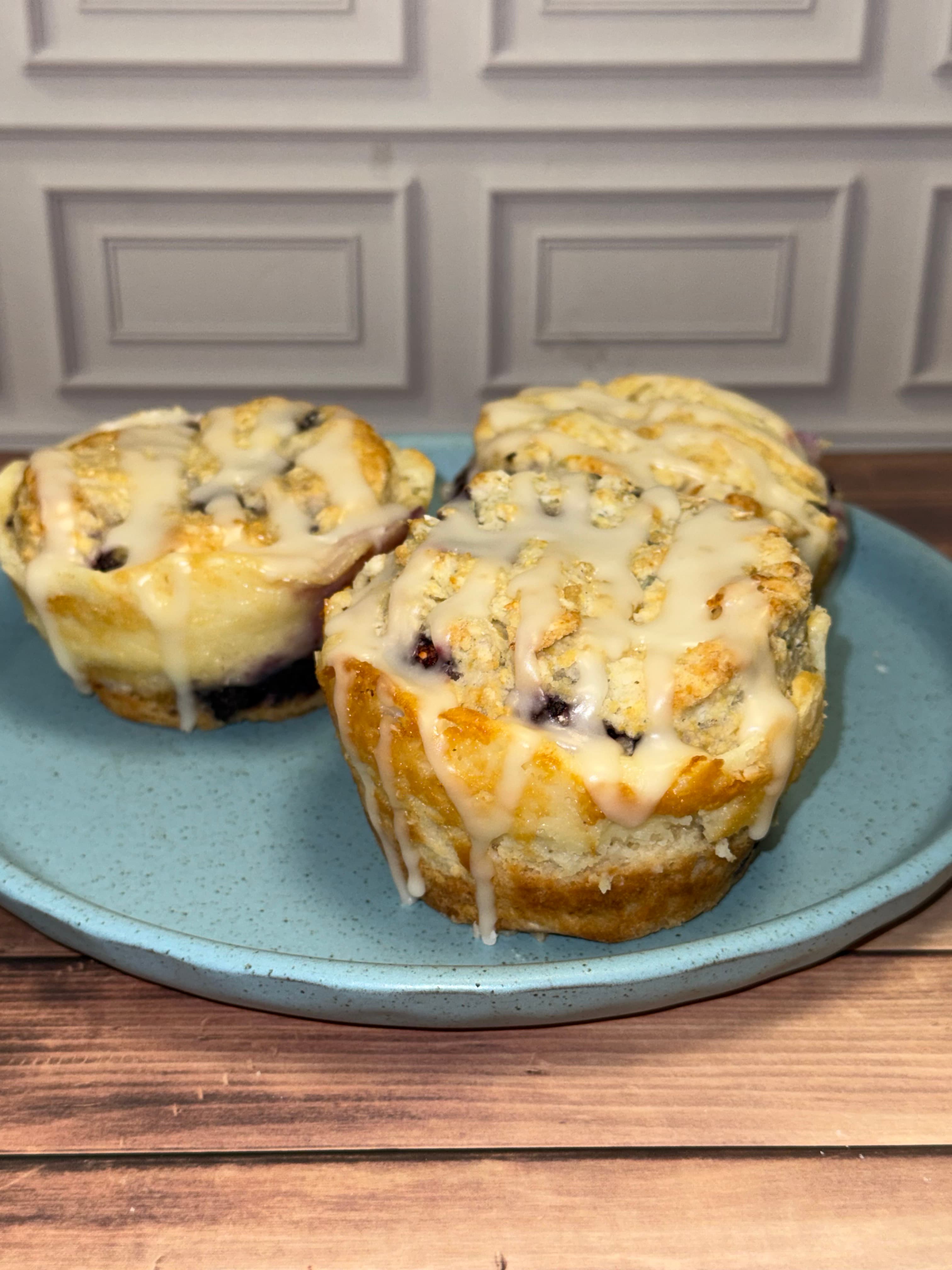 Blueberry Fruit and Cream Scuffins with vanilla glaze on a blue plate
